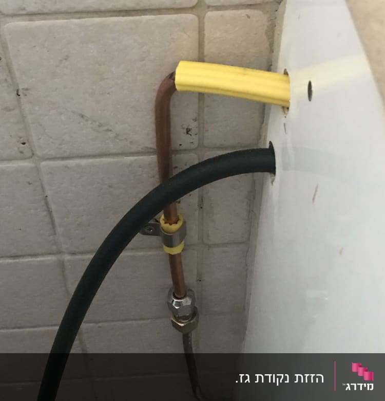 צינור נחושת עם חיבורי פלסטיק צהובים וקיר אריחים